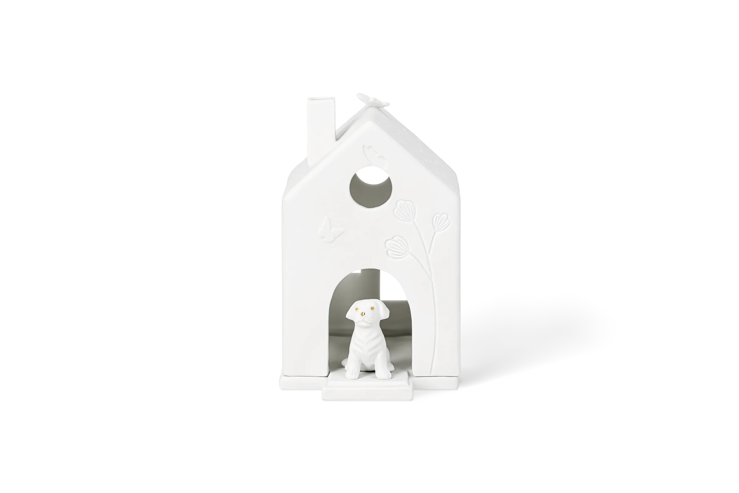 Weißes Porzellanlichthaus mit Hund in der Tür, hochgeprägten Blumen und Schmetterling in der Vorderansicht.