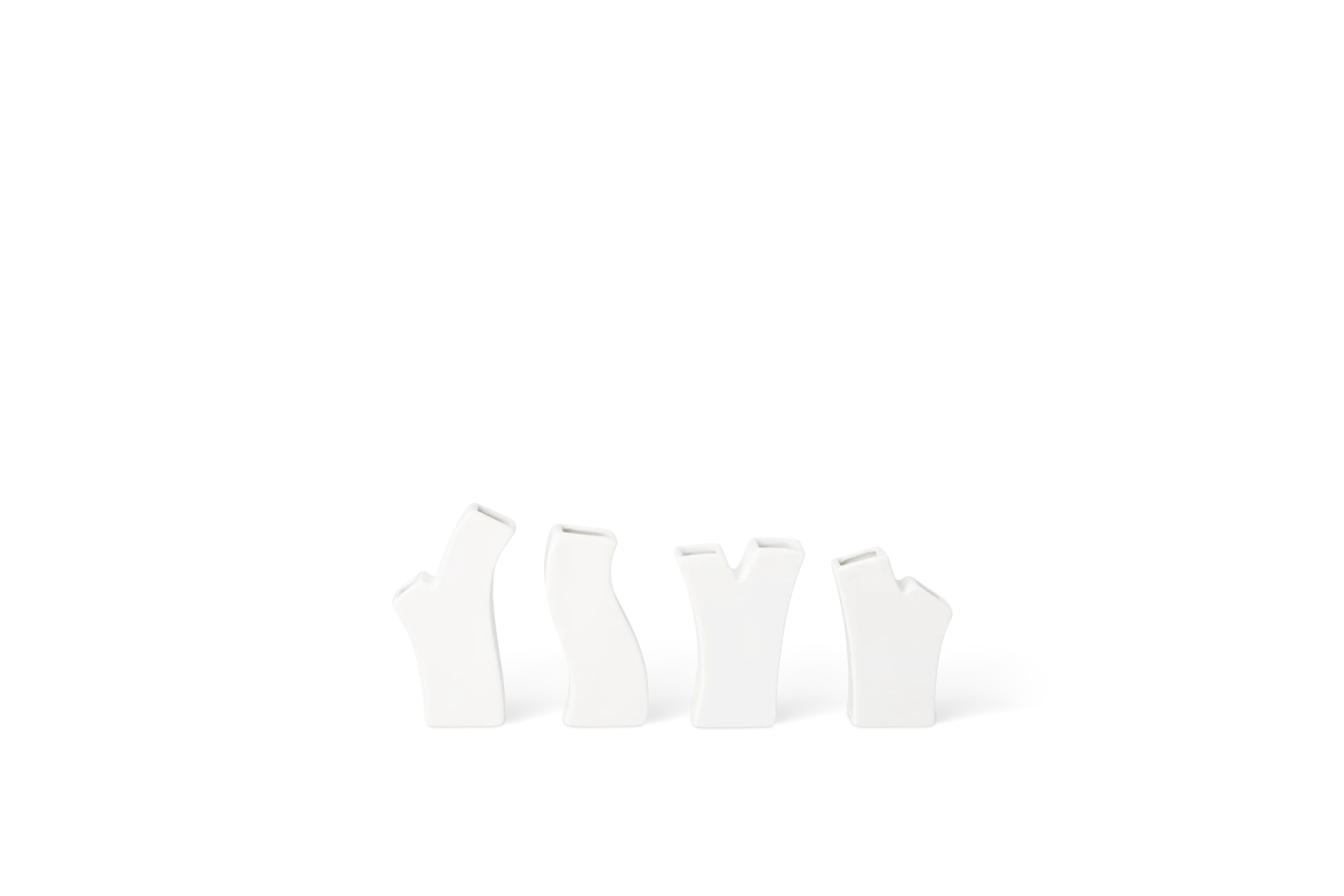 Vier weiße Mini-Vasen in organischen, unterschiedlich geformten Silhouetten, in der Rückansicht.