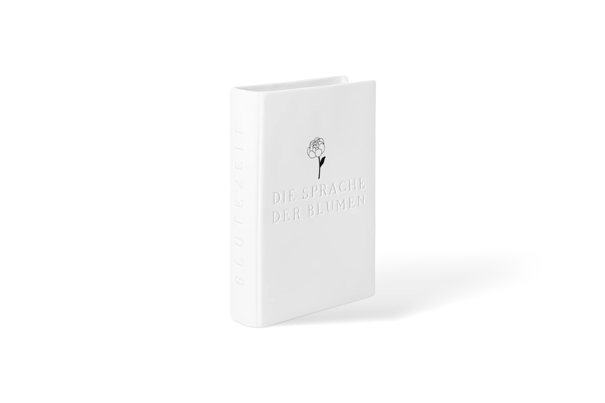 Weiße Vase in Buchform mit eingeprägtem Schriftzug Die Sprache der Blumen und Blumenmotiv, vordere Linksansicht.