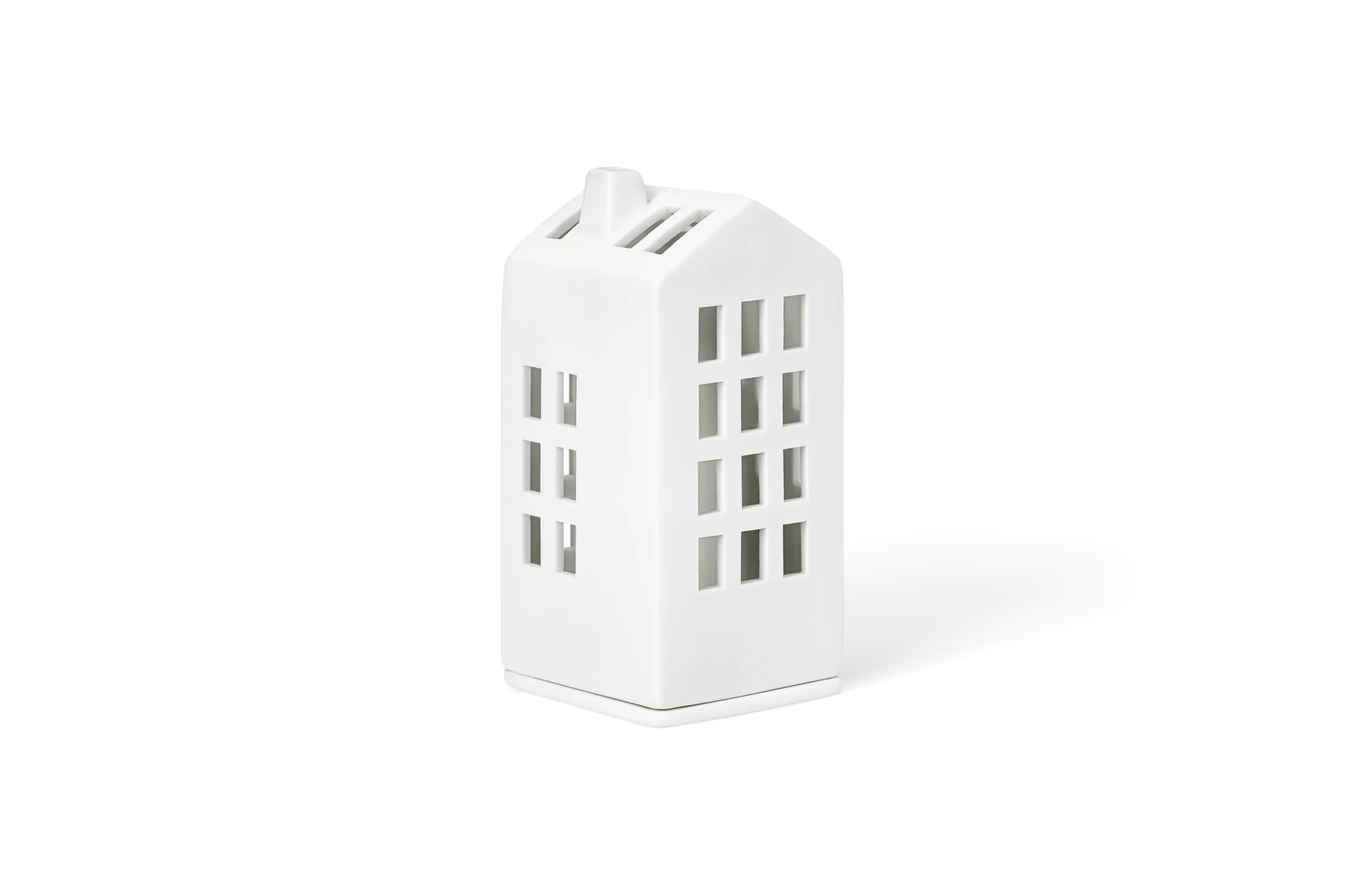 Mini-Lichthaus Rathaus Weißes Porzellan-Lichthaus in hoher rechteckiger Form mit ausgestanzten Fenstern und Schornstein, in der vorderen Linksansicht.
