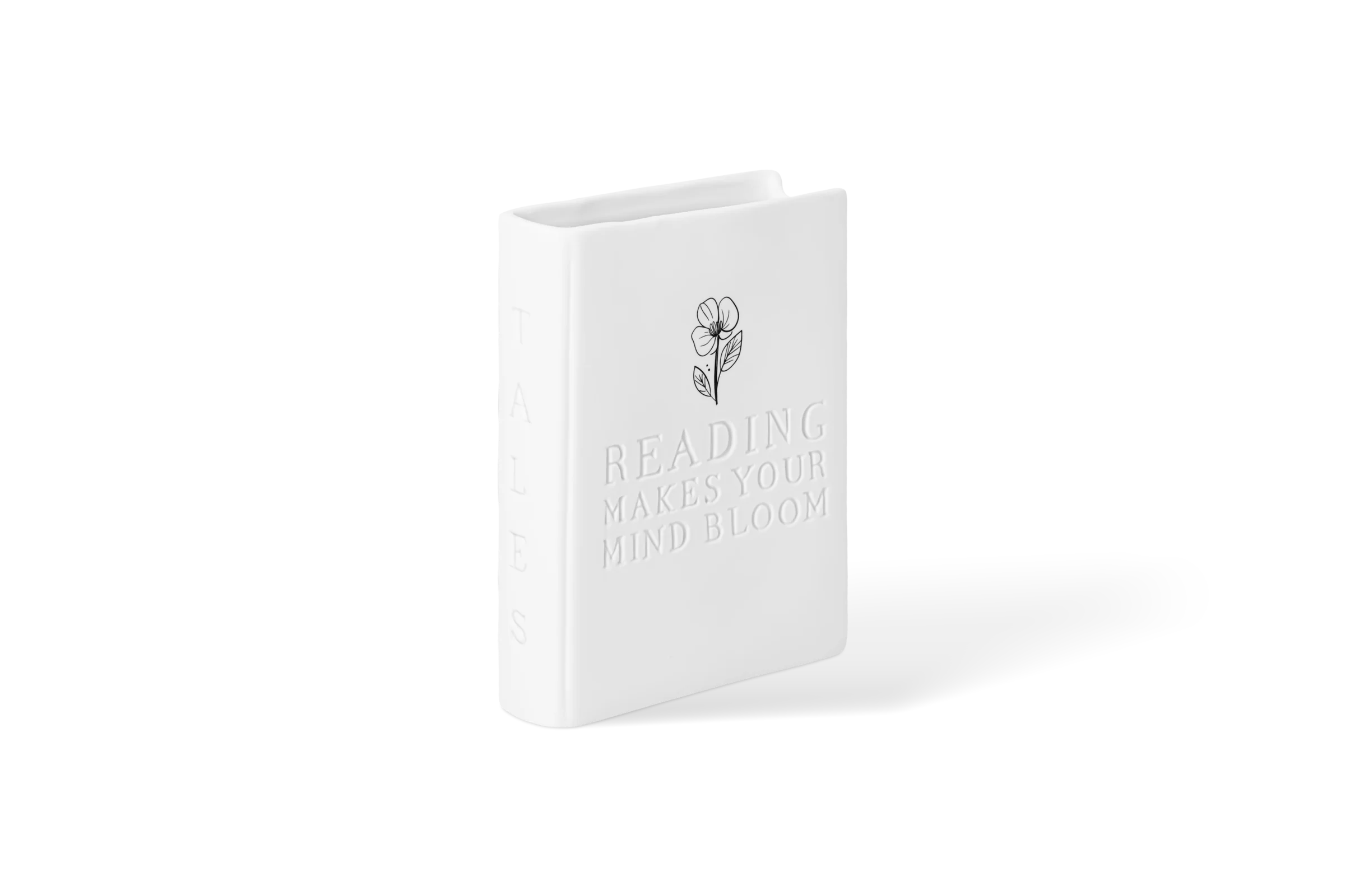 Weiße Vase in Buchform mit eingeprägtem Schriftzug und Blumenmotiv in der vorderen Linksansicht.