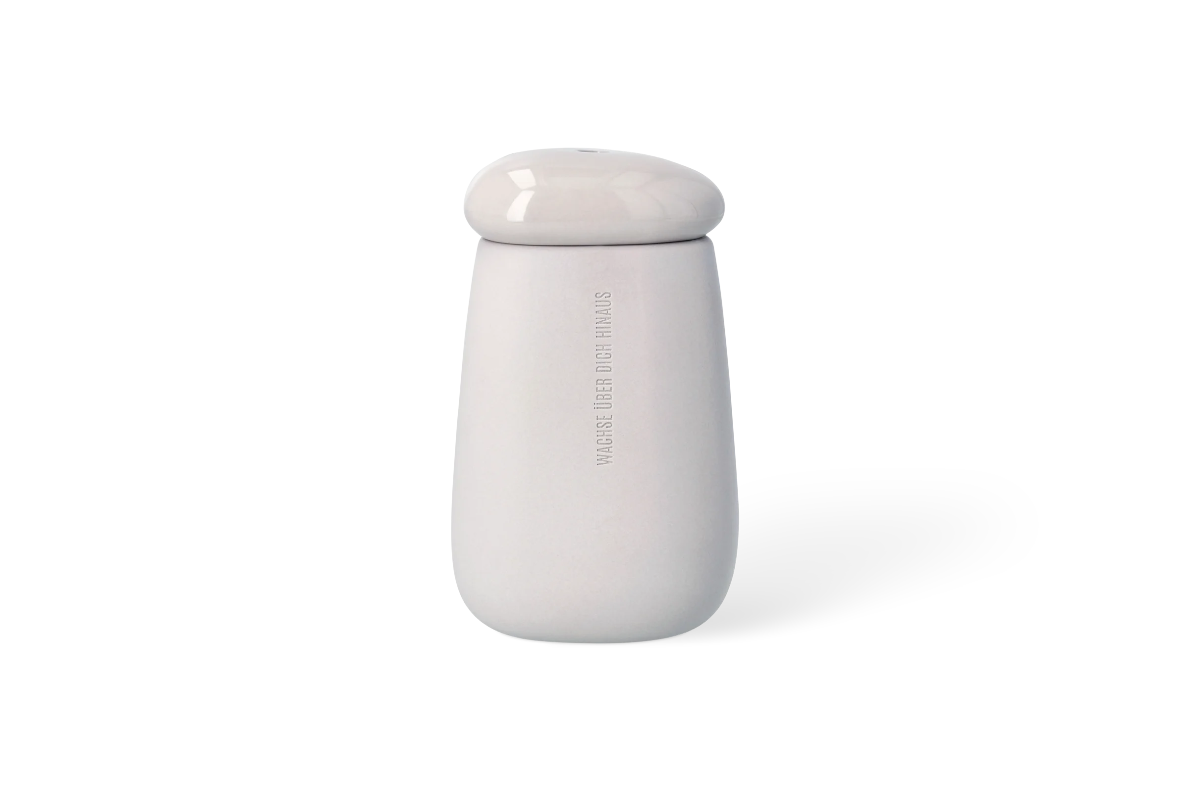 Vase Wachse über dich hinaus Graue Vase mit abnehmbarem Deckel und tiefgeprägtem Schriftzug Wachse über dich hinaus in der Vorderansicht.