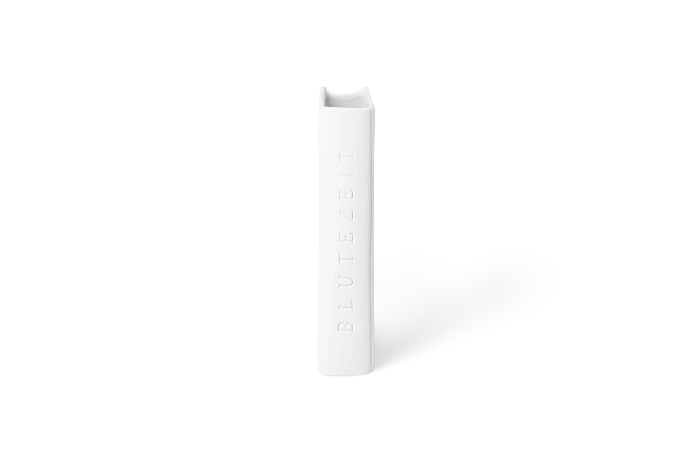 Weiße Porzellanvase Leseglück in Buchform mit eingeprägtem Schriftzug Blütezeit, in der Linksansicht.