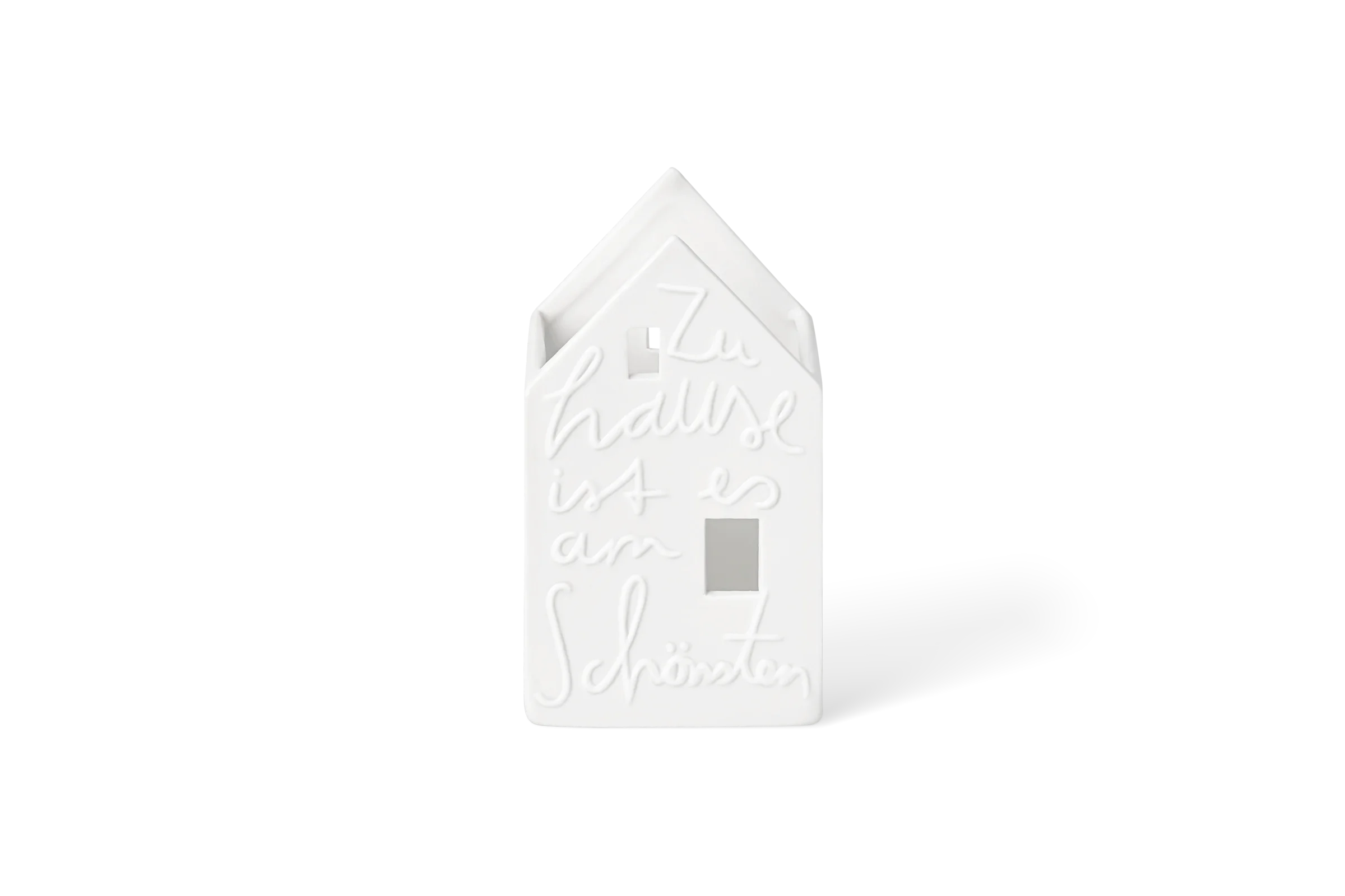 Weißer Teelichthalter Stadtgeflüster in Hausform mit hochgeprägtem Schriftzug Zuhause ist am schönsten in der Vorderansicht.