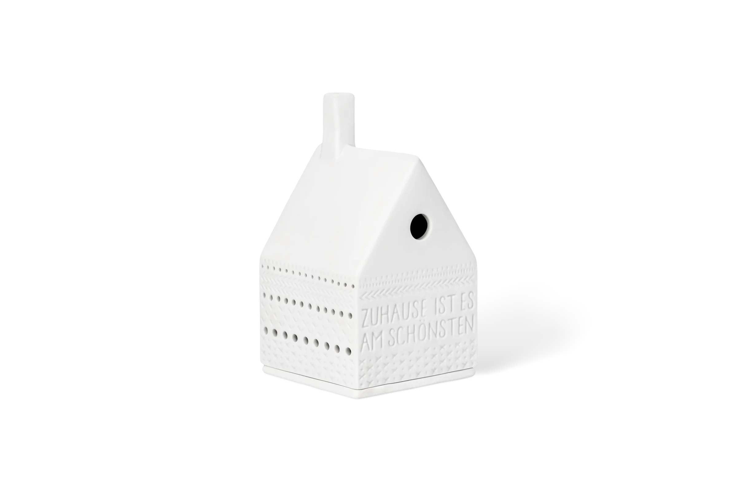 Lichthaus Zuhause ist es am schönsten Weißes Porzellanlichthaus mit tiefgeprägtem Schriftzug Zuhause ist es am schönsten und Lichtpunkten in der vorderen Linksansicht.